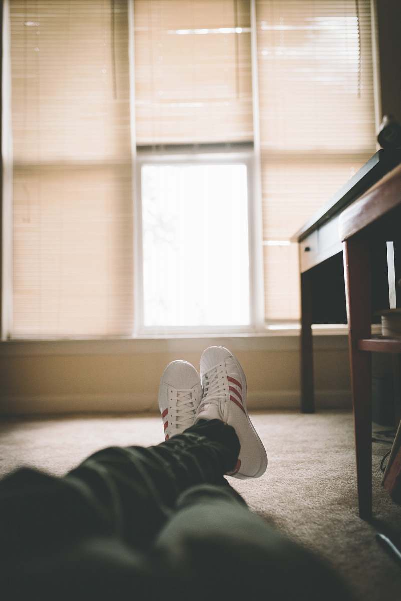 clothing person on floor beside desk footwear