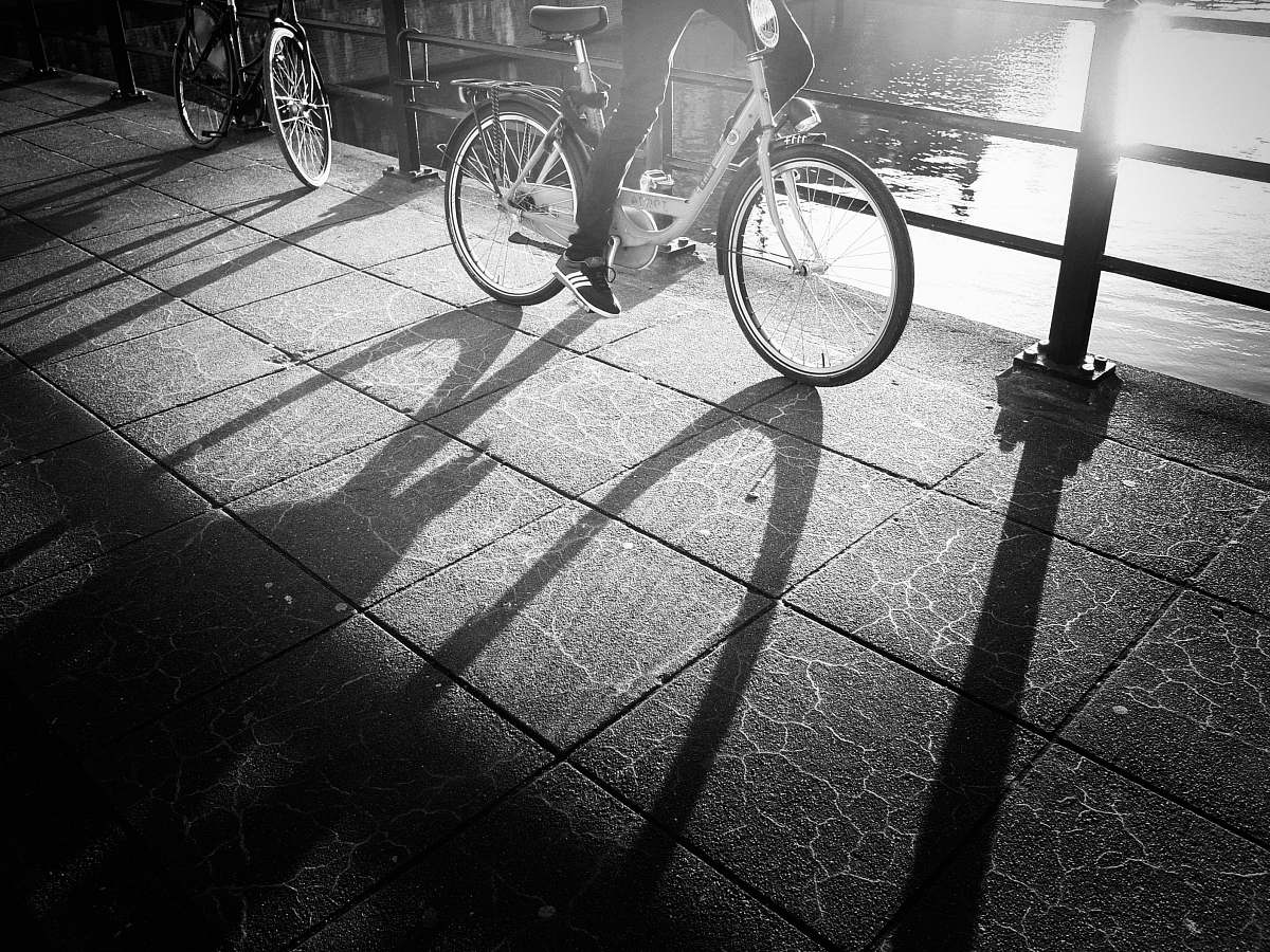 bicycle grayscale photo of a person wearing sneakers riding a bicycle bike