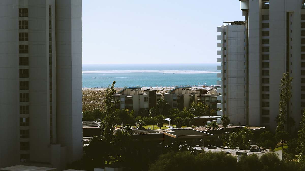 city white high rise buildings near beach housing