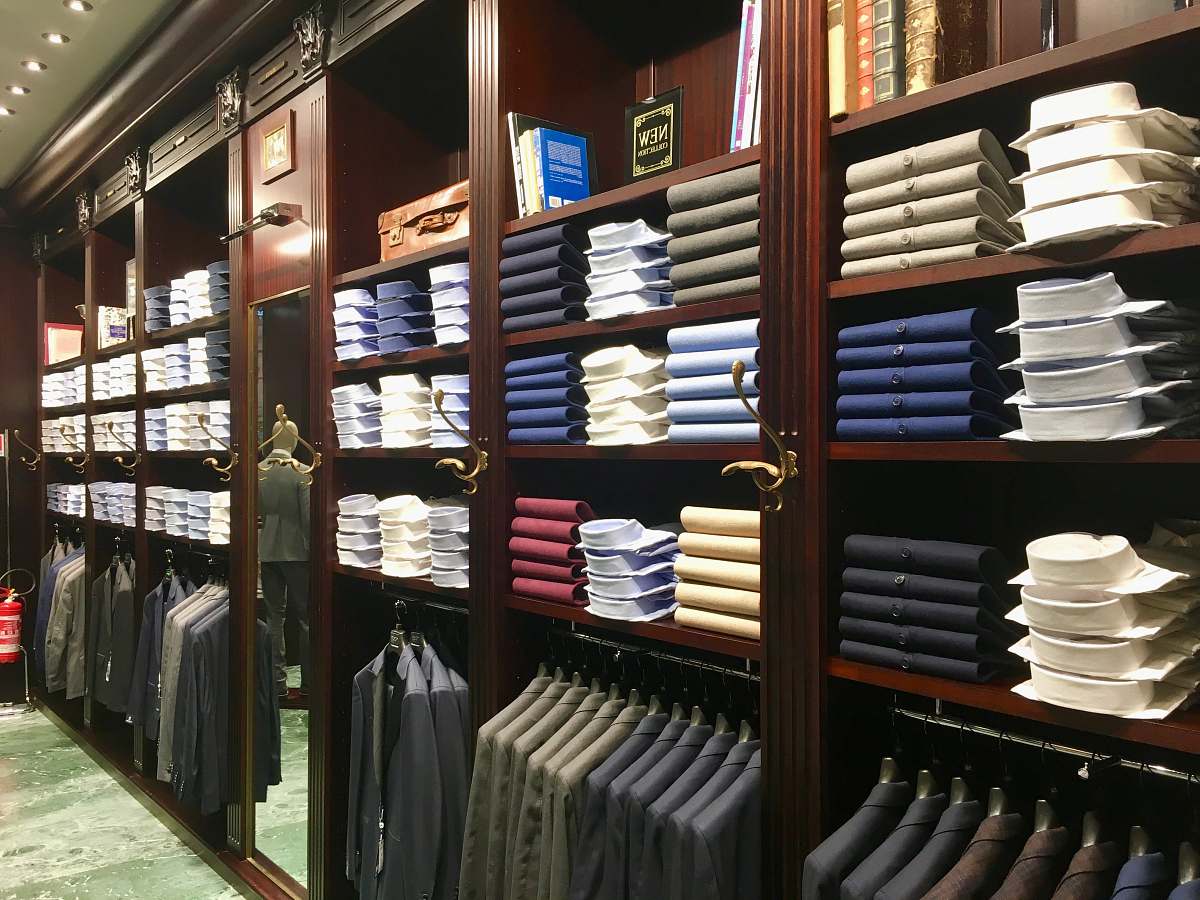 indoors assorted-colored clothes on brown wooden shelf shelf