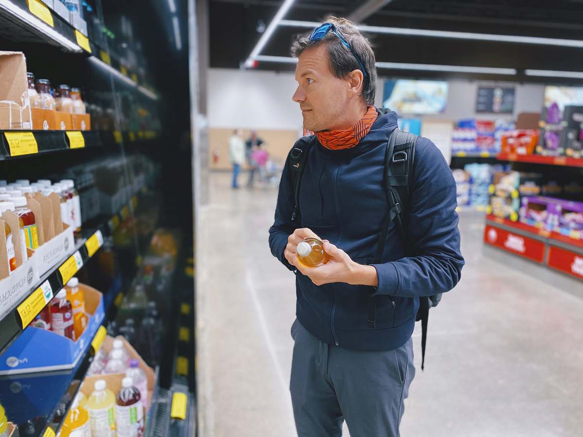 shop man standing beside display shelf grocery store