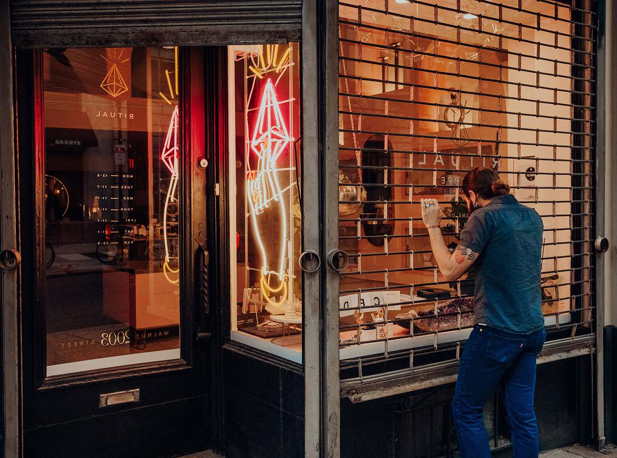 person man standing in front of structure shop