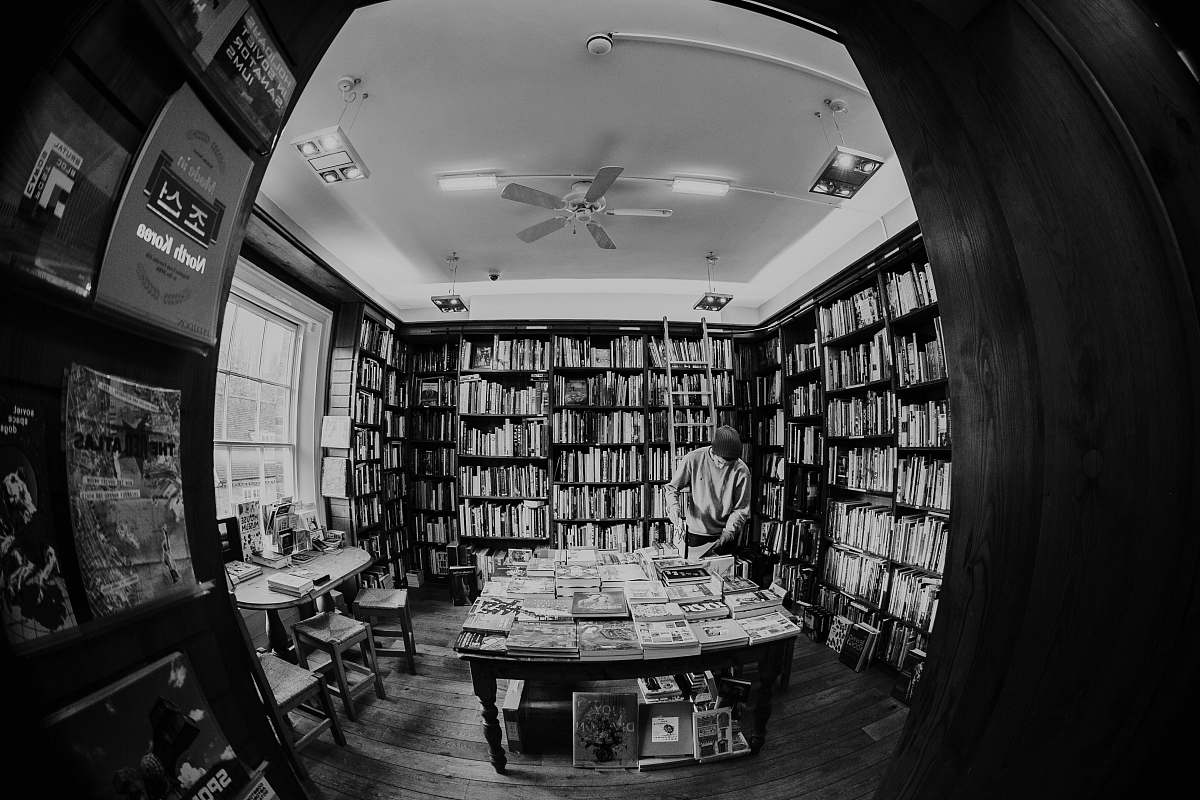 person person inside library black-and-white
