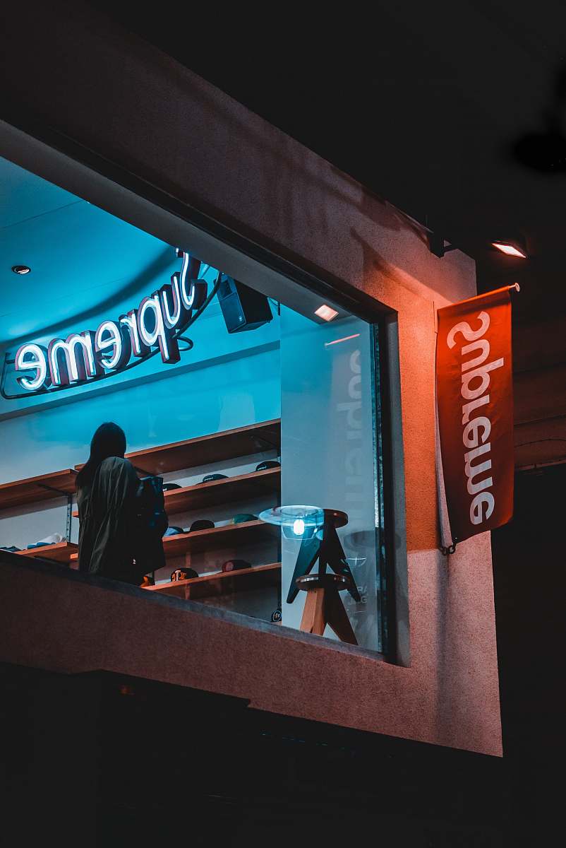 person red and white Supreme signage shop