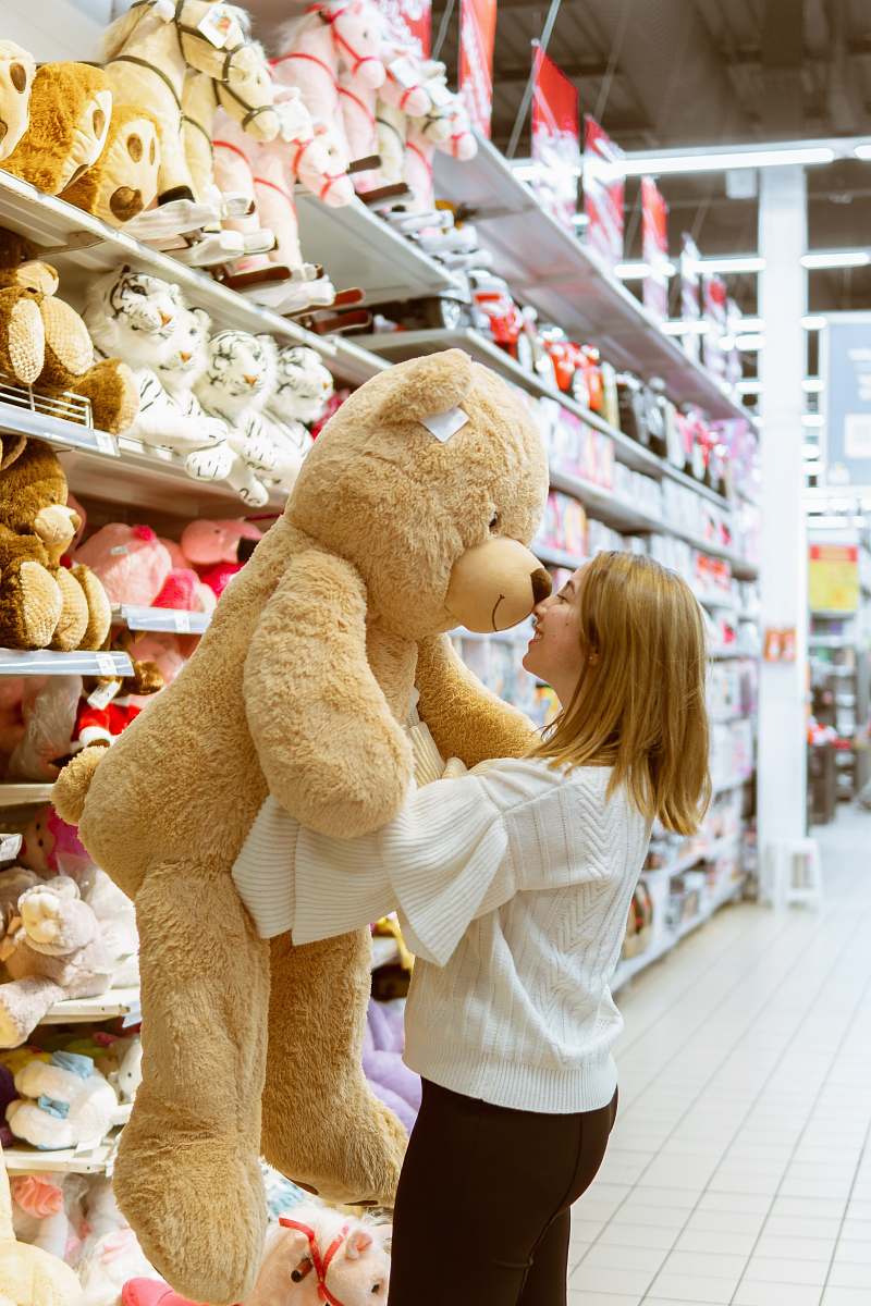 shop woman carrying life size bear plush toy teddy bear