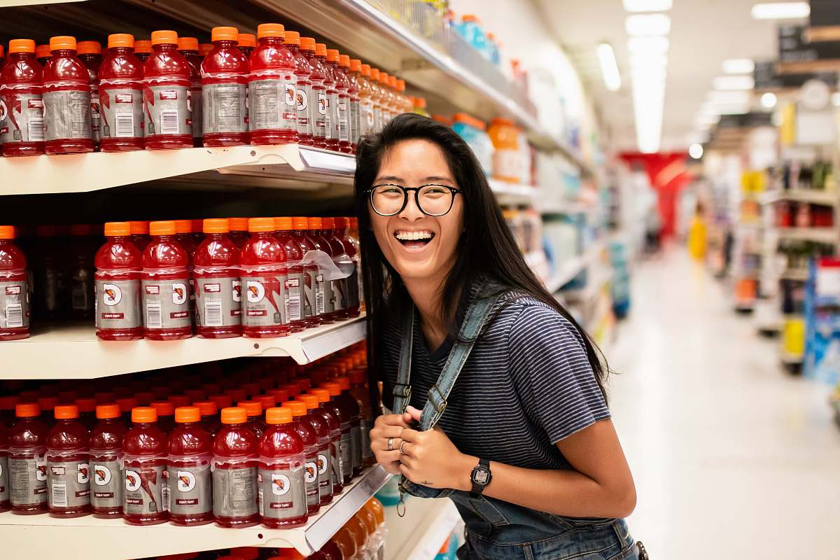 person woman laughing while standing beside Gatorade bottlles accessories