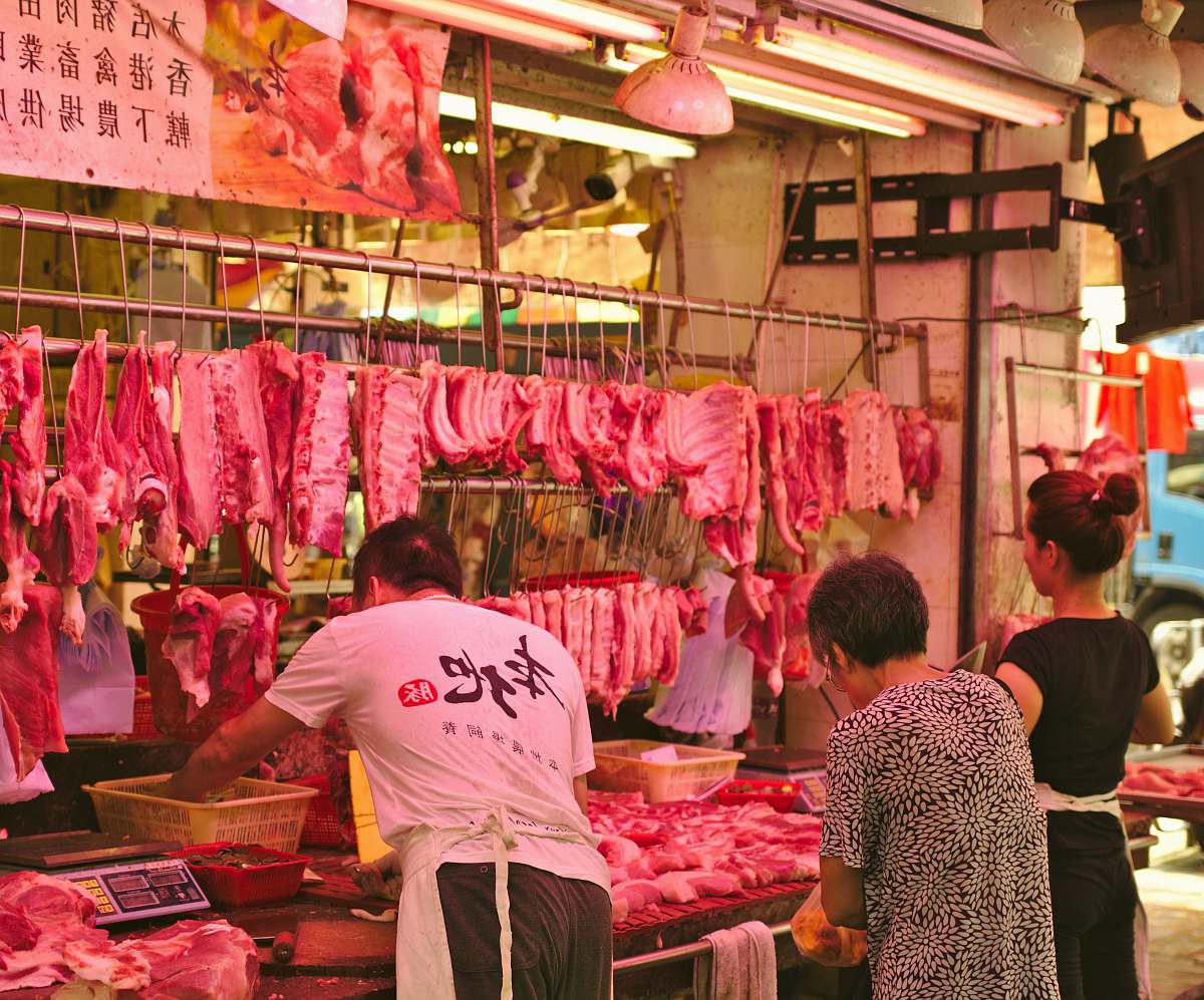 human man and woman vending raw meats butcher shop