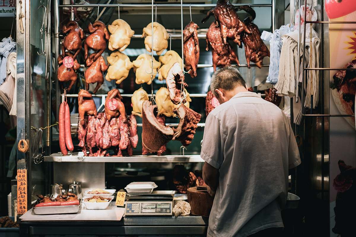 human man standing on store butcher shop