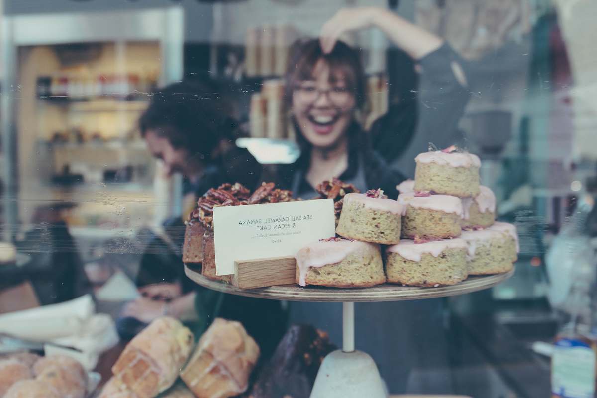 human reflection of smiling woman on food display shelf people