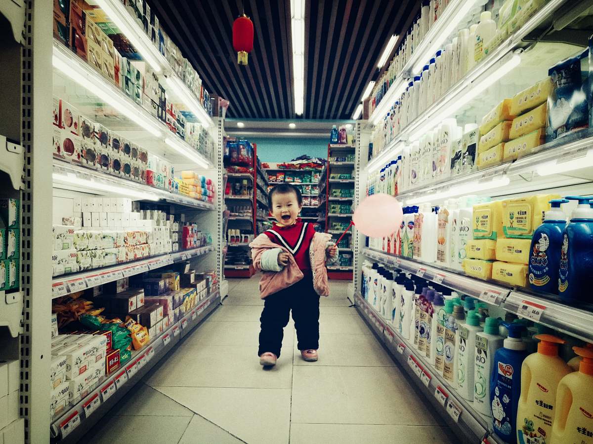 supermarket baby walking between white shelves market