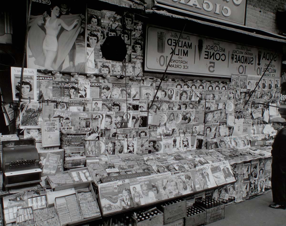 black-and-white grayscale photo of magazines newsstand