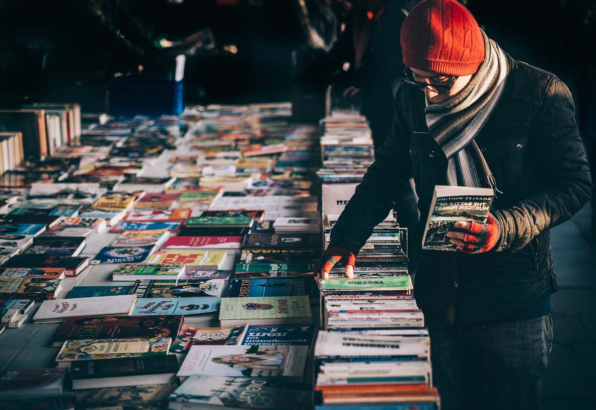 person man picking up book ob book sale books