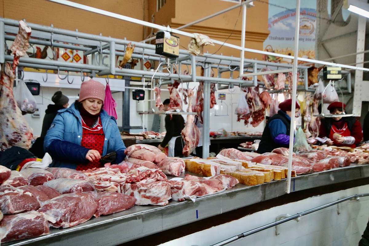 human photography of women standing in front of meats butcher shop