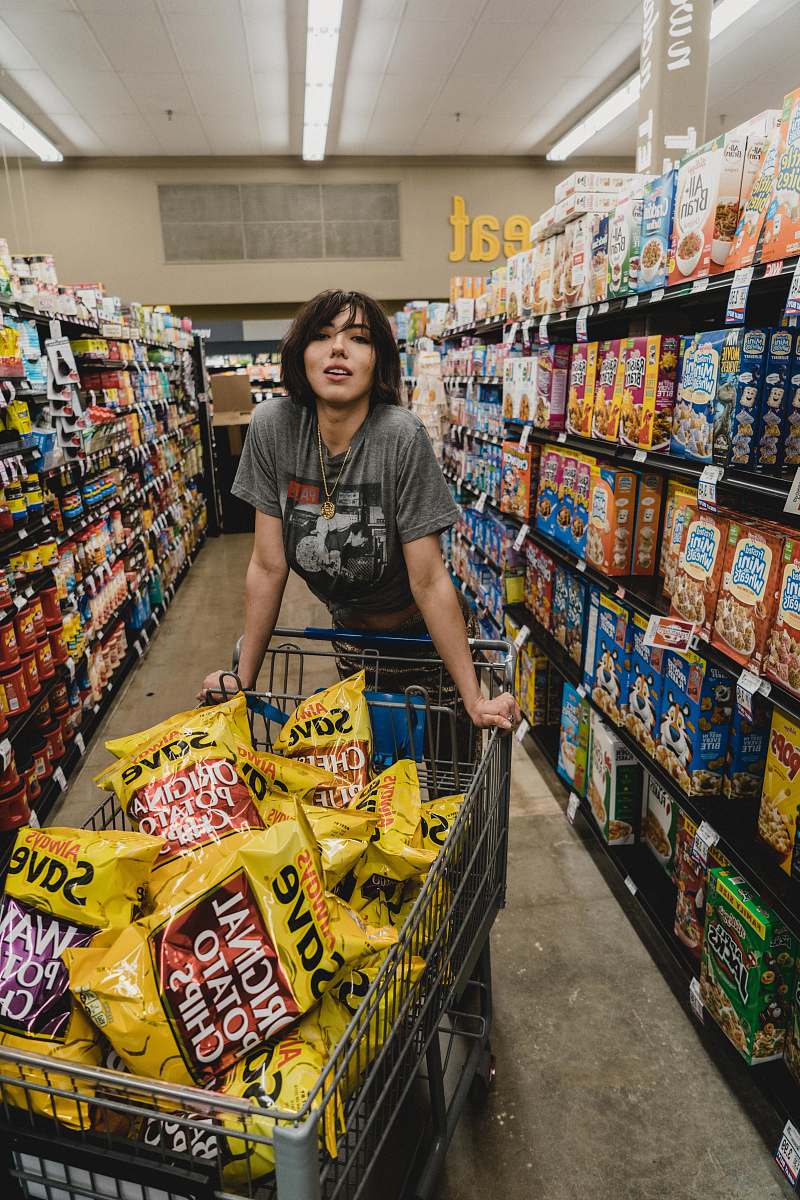 person woman in gray shirt holding shopping cart with Original Potato Chips bag lot human