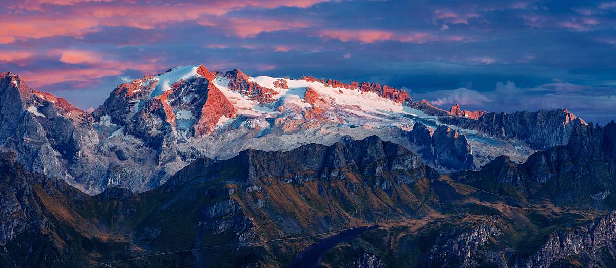 nature aerial photography of hills overlooking snow capped mountain at daytime outdoors