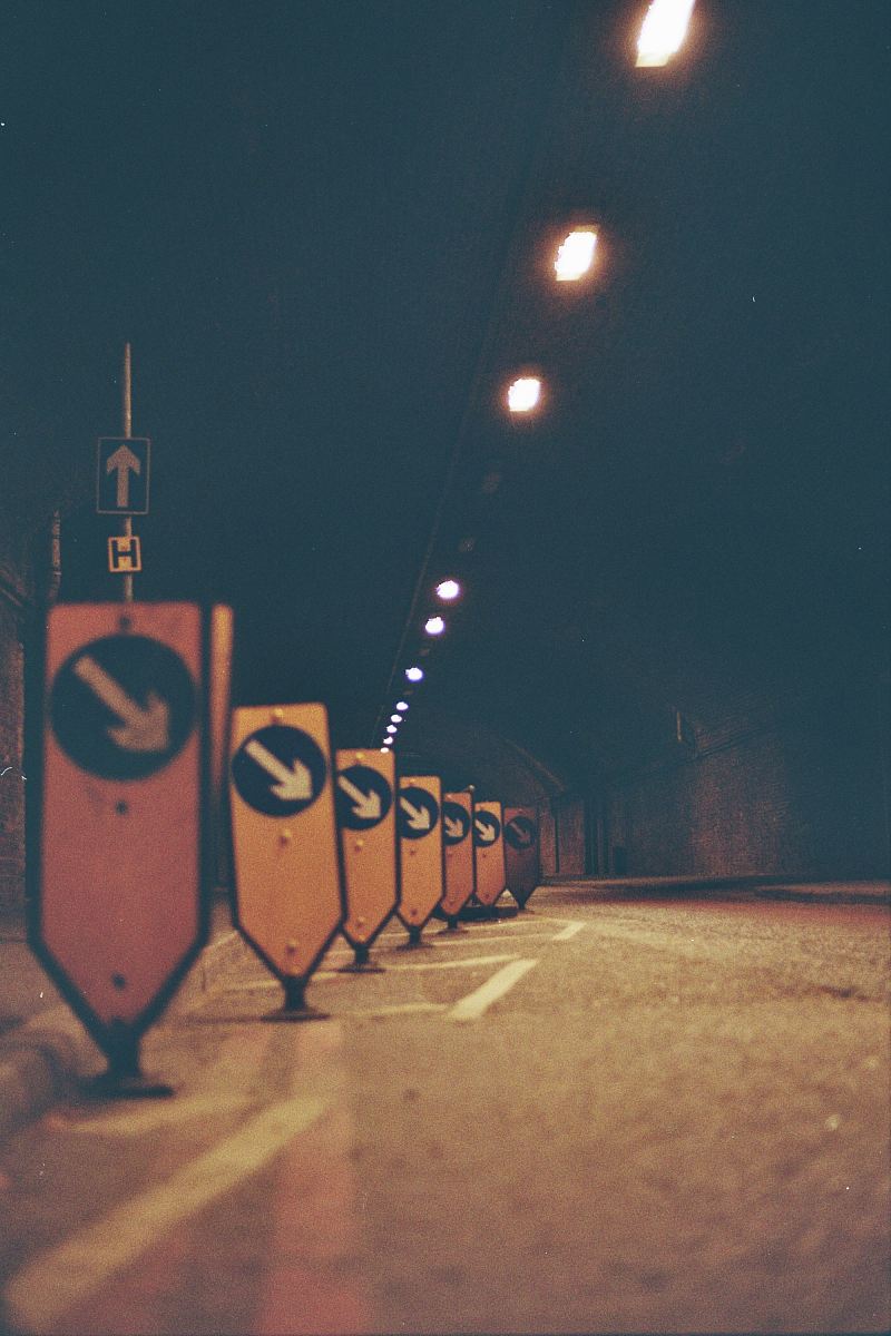 a street sign in the middle of a dark street