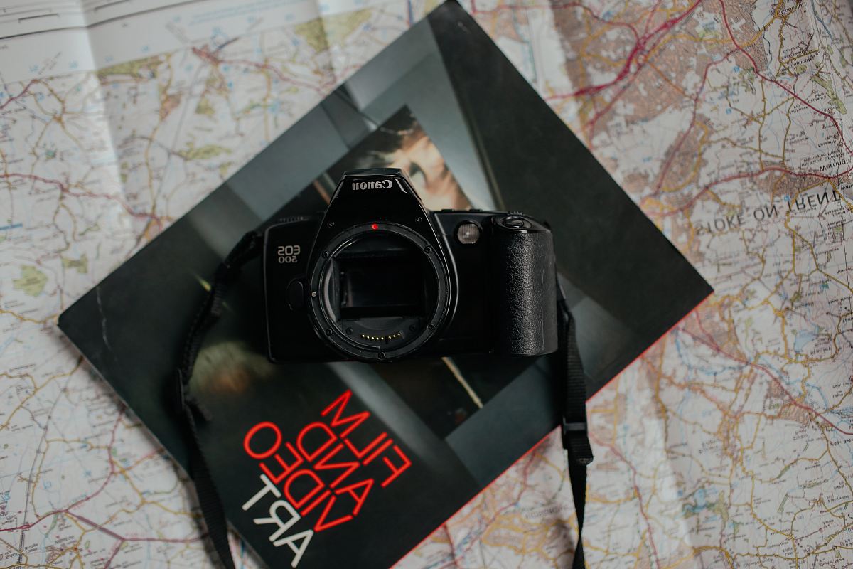 black Canon DSLR camera on top of black book