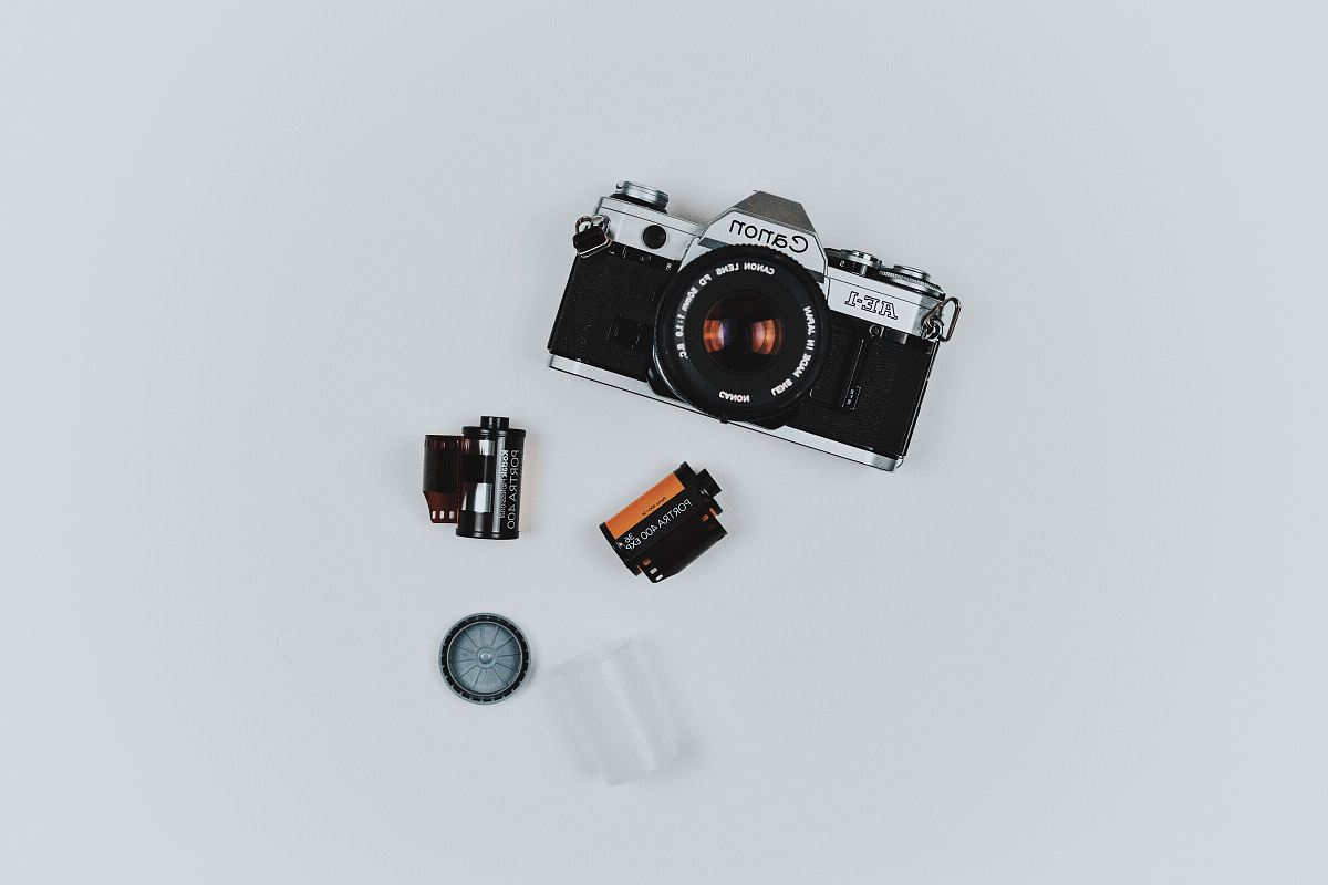 black Canon film camera with two films in flat lay photography