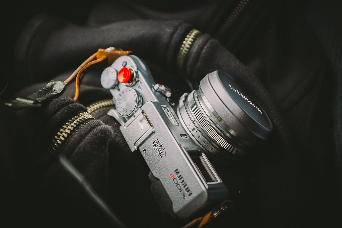 closeup photo of mirrorless camera on zip-up top