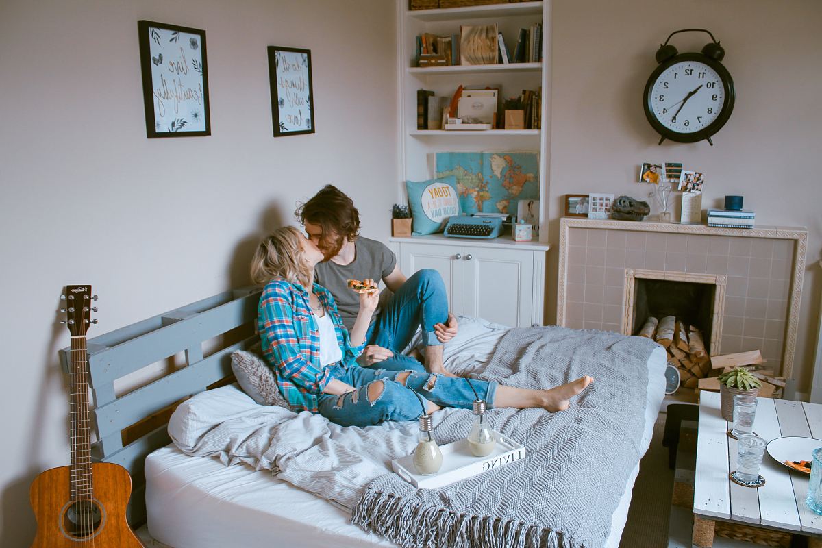 man and woman kissing on bed
