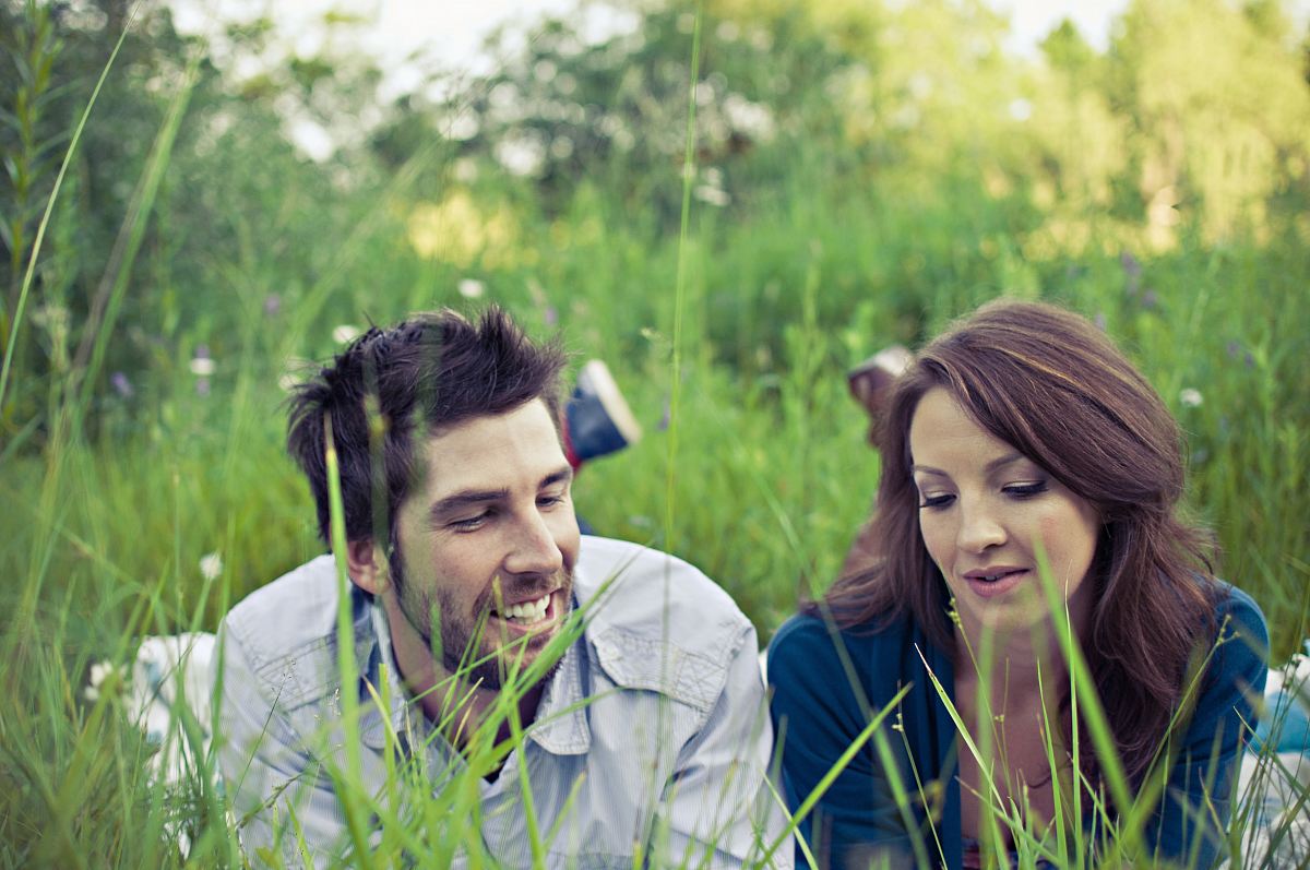 man and woman lying on the grass