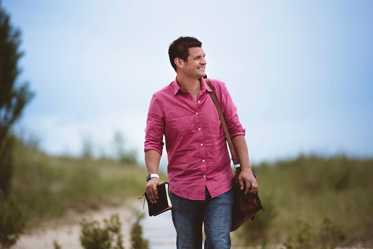 man carrying bag walking on street