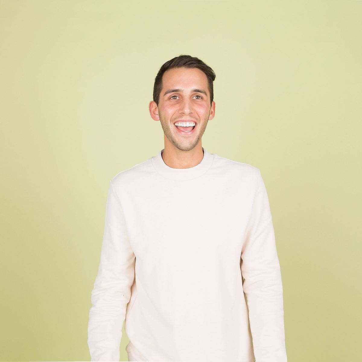 man wearing white crew-neck long-sleeved shirt standing inside well lighted room