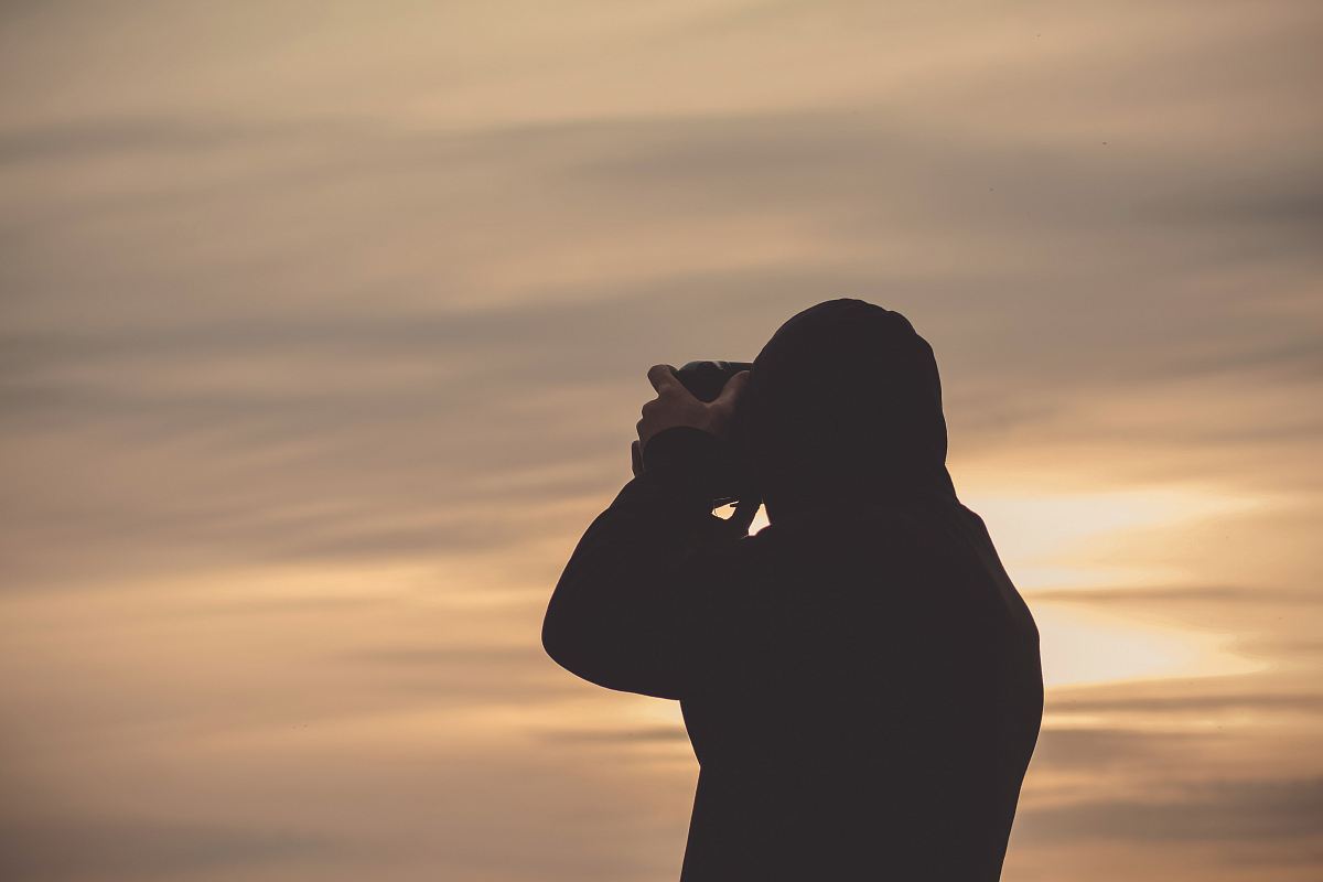 person using camera fronting the sky