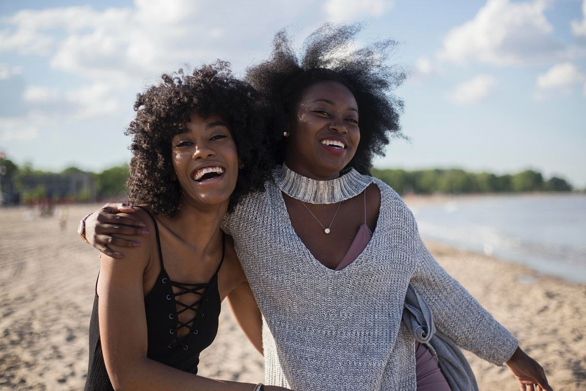 photo of woman beside another woman at seashore