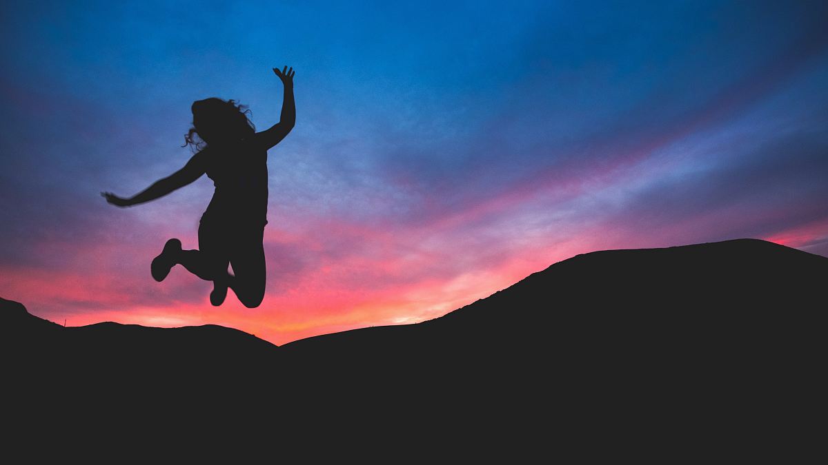 silhouette of person jumping during dawn