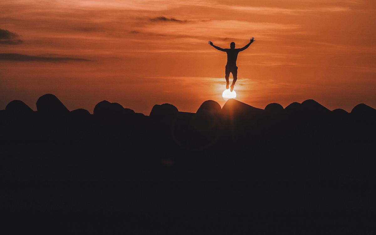 silhouette of person jumping in mid air