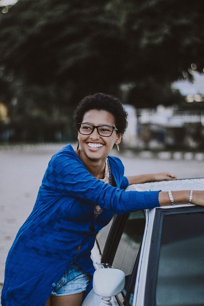 woman beside white vehicle during daytime