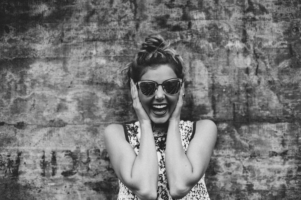 woman covering her ears while leaning on wall