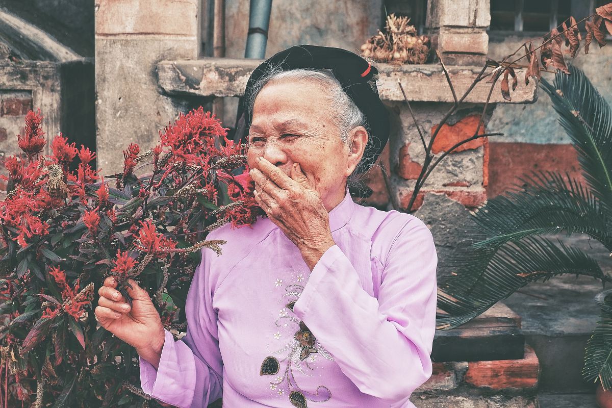 woman holding red petaled flowers