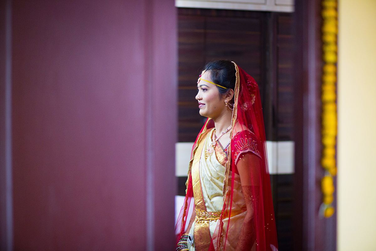woman in sari dress standing near purple wall