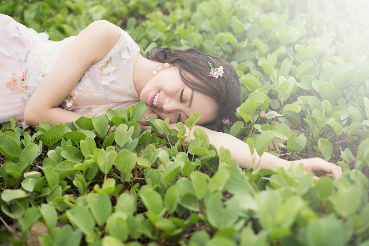woman lying on green grass