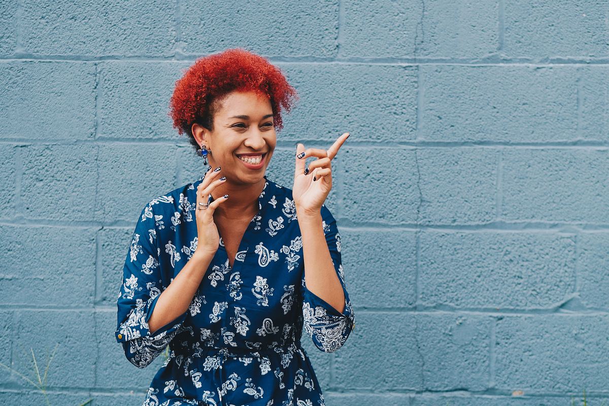woman smiling while pointing on her right side