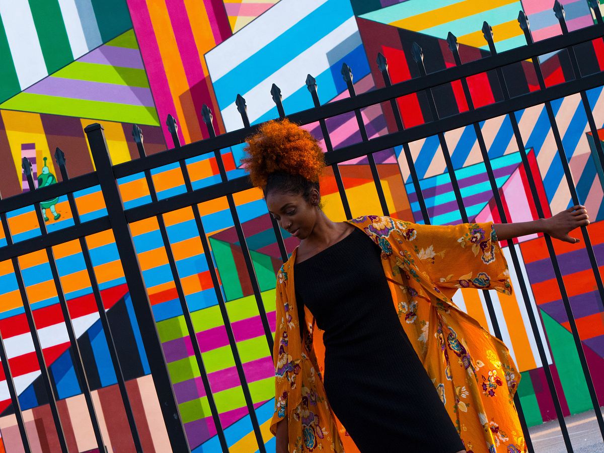 woman standing in front of black gate