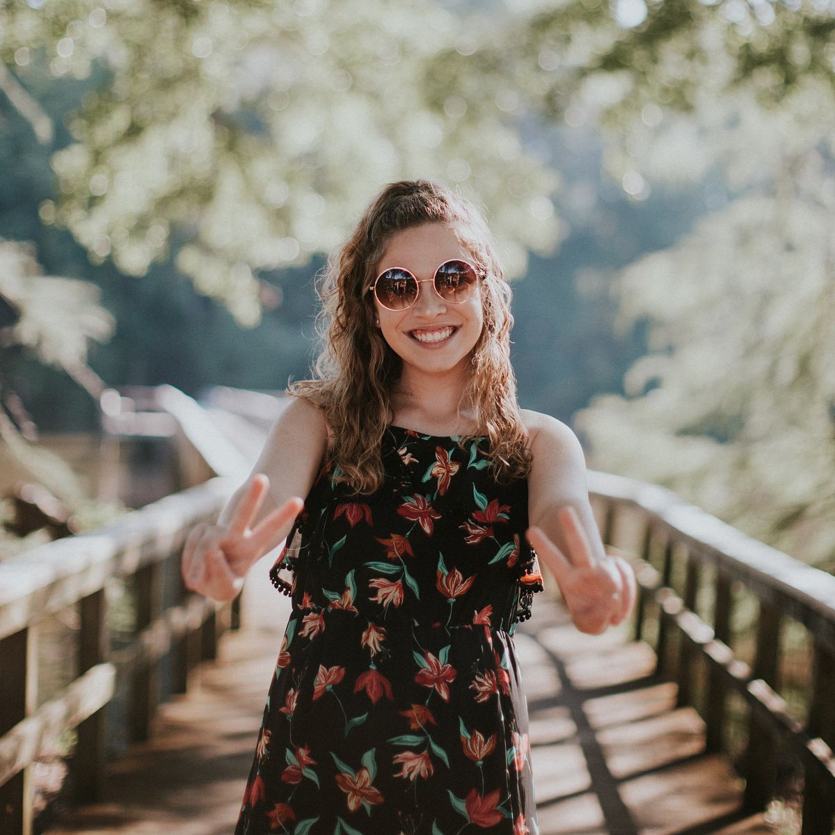 woman standing on wooden bridge