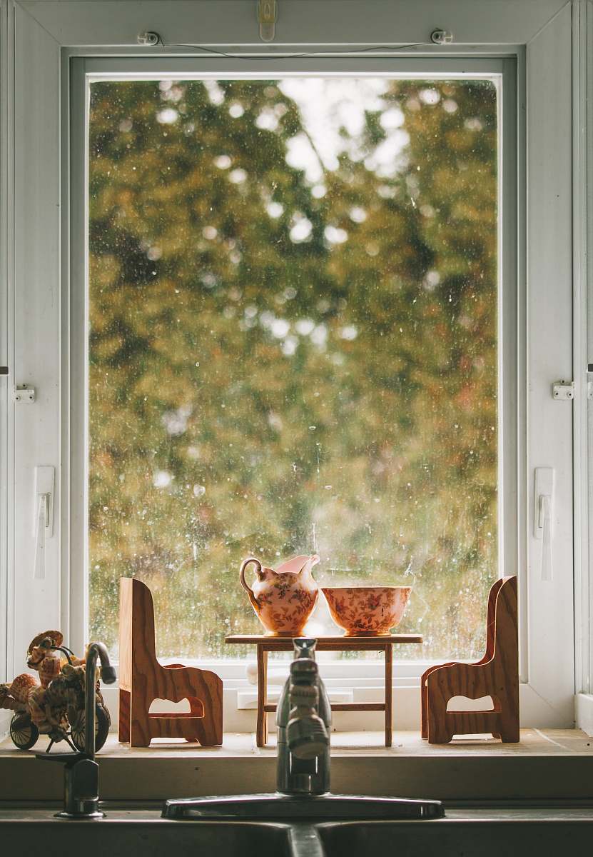 person miniature chairs and table near window window