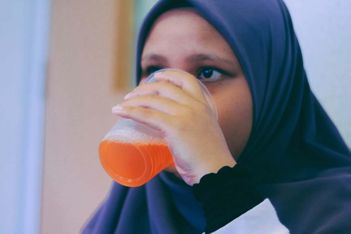 person woman in black hijab headdress white drinking people