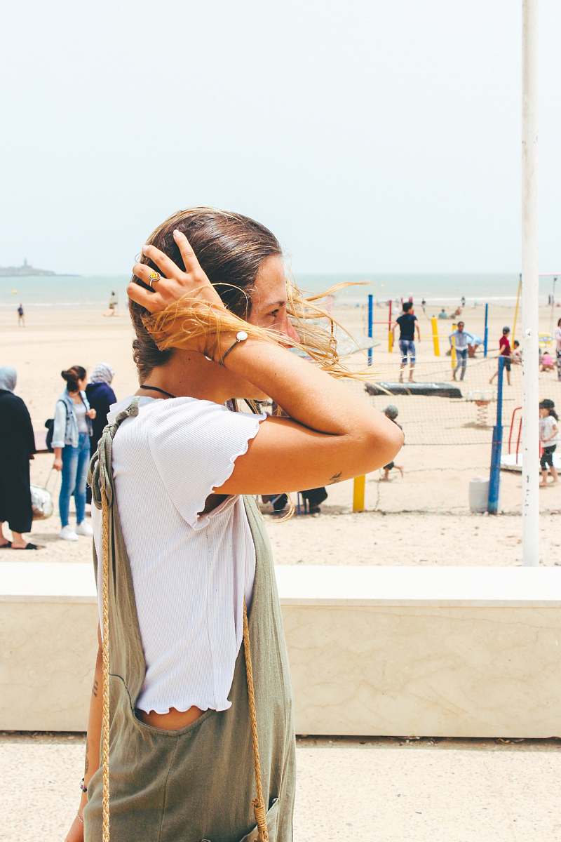 person woman on beach with her hands on head people