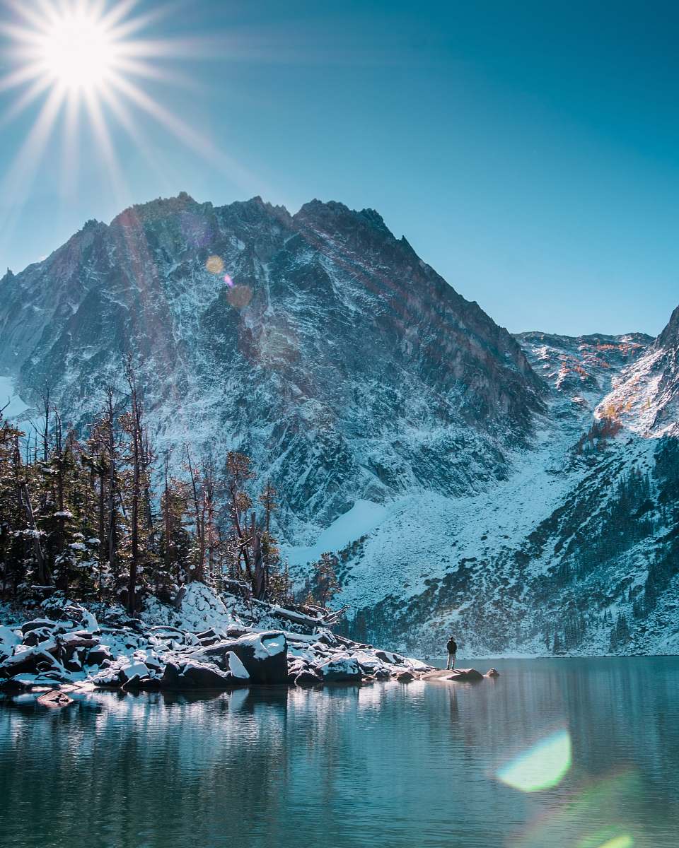snow man standing beside of the lake mountain