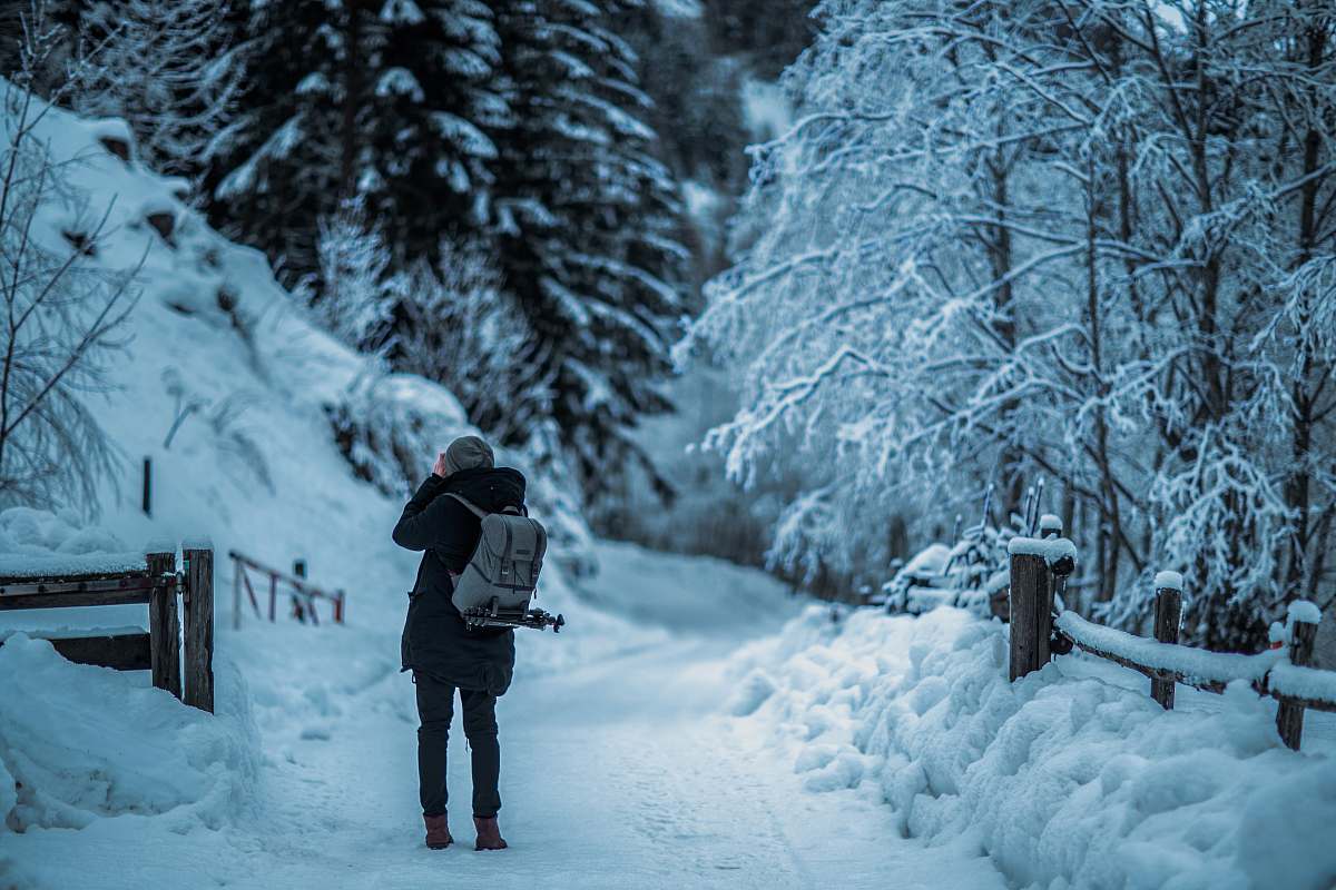 person man standing in middle of snowfield during daytime winter