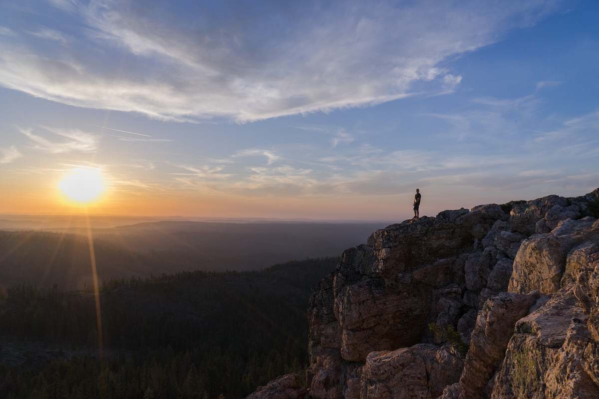 sun person standing on mountain cliff view