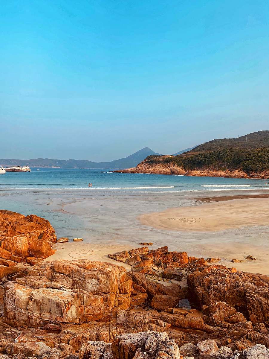 shoreline seashore near mountain during daytime promontory