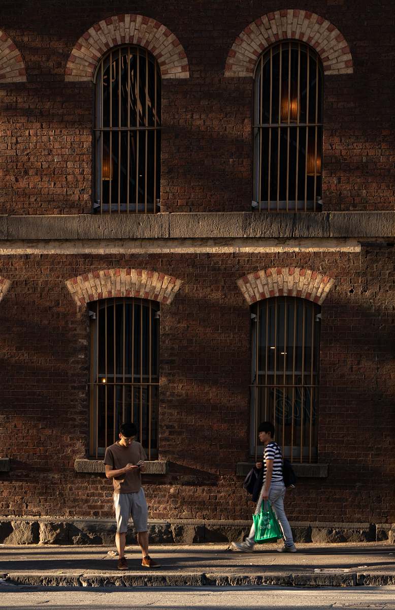 human two men standing near brown building path