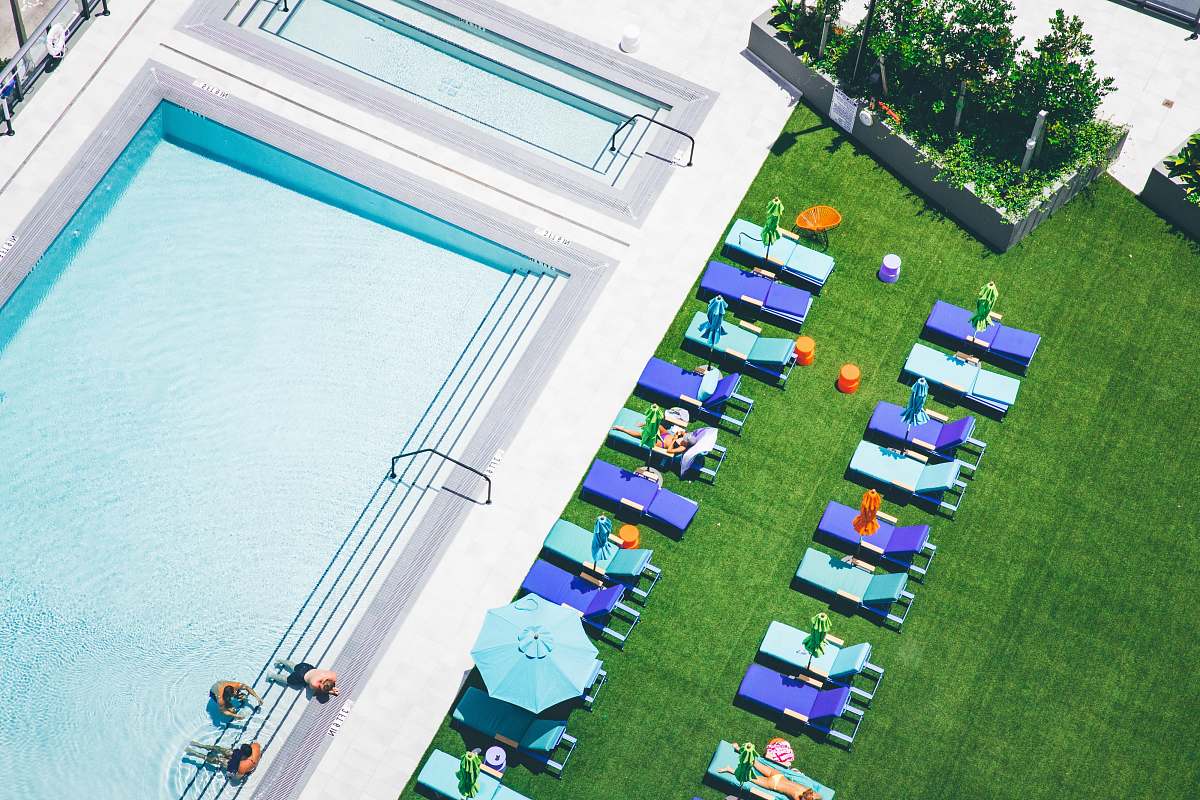 grass aerial photo of sunlounger near water pool toy