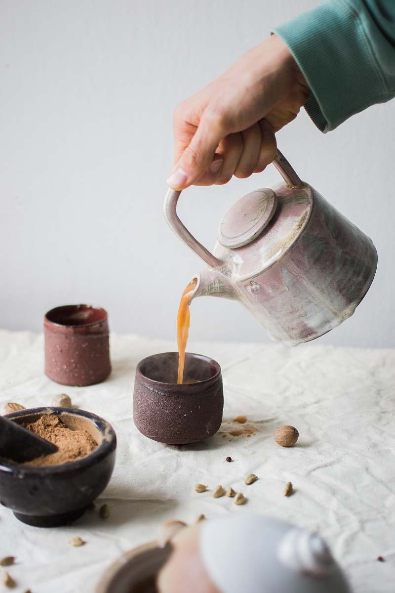 human person pouring coffee on brown cup person