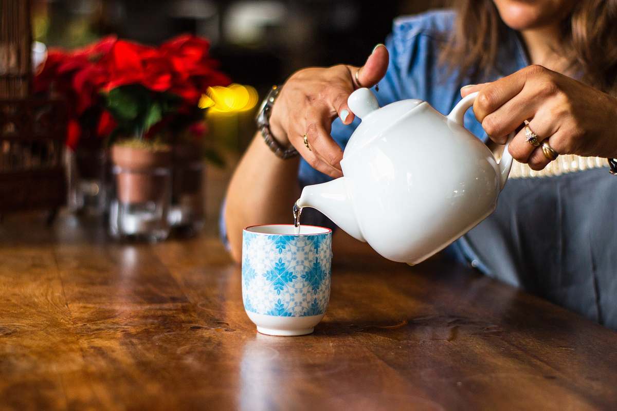 person unknown person holding white ceramic kettle cup